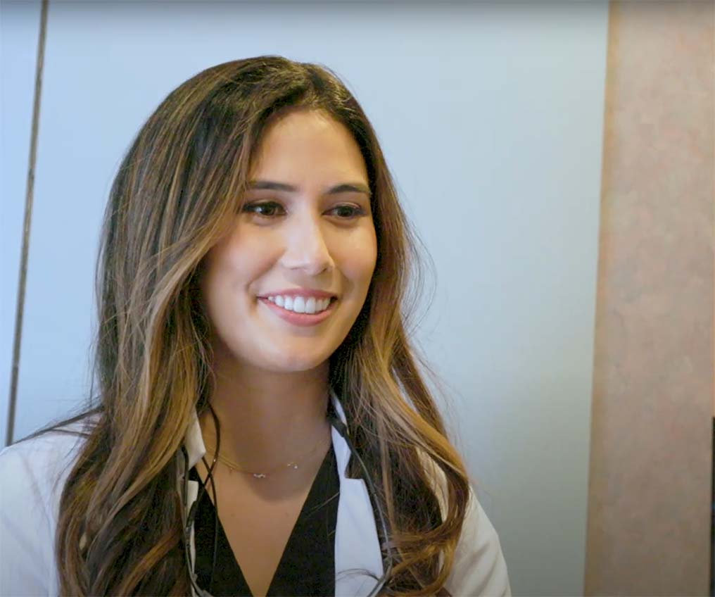 Smiling Dr. Etesse discussing holistic dental care with a patient